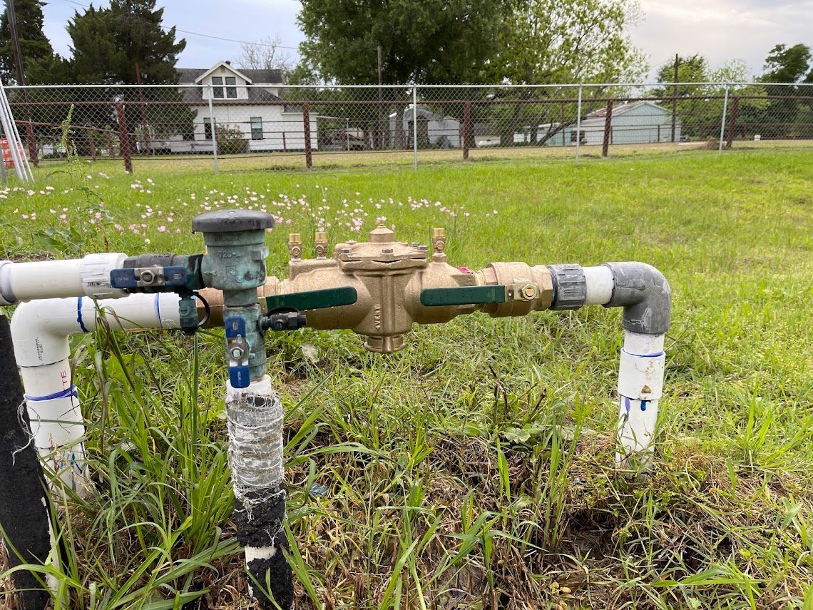 Large bronze RPZ backflow preventer in an open field