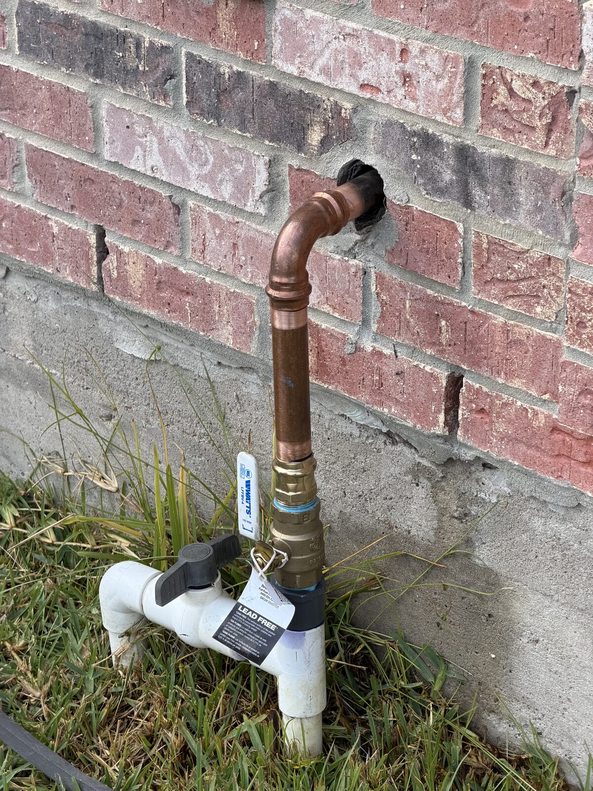 Repaired copper water line at a brick wall with a new Watts shutoff valve
