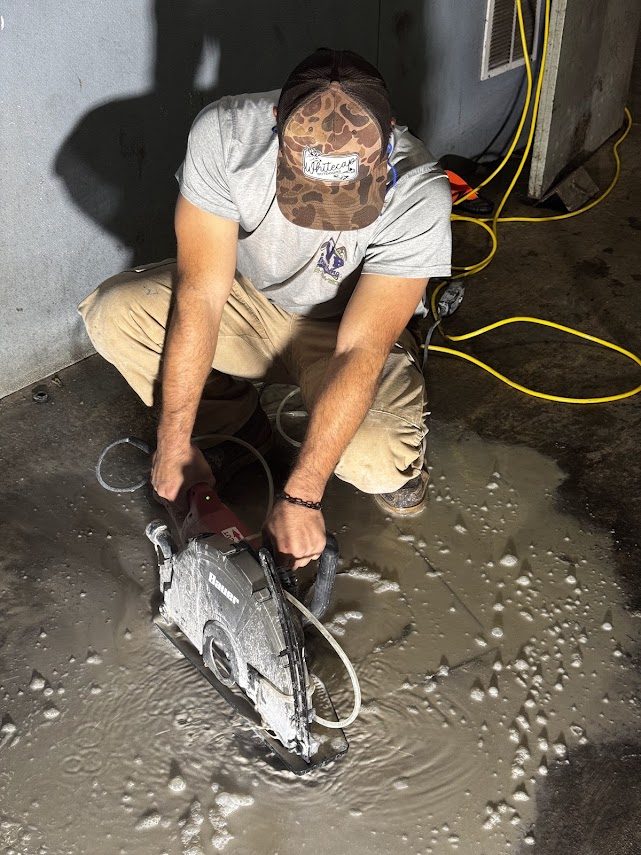 Concrete saw cut into a slab floor on a Dayton slab leak repair, with water standing on the surface
