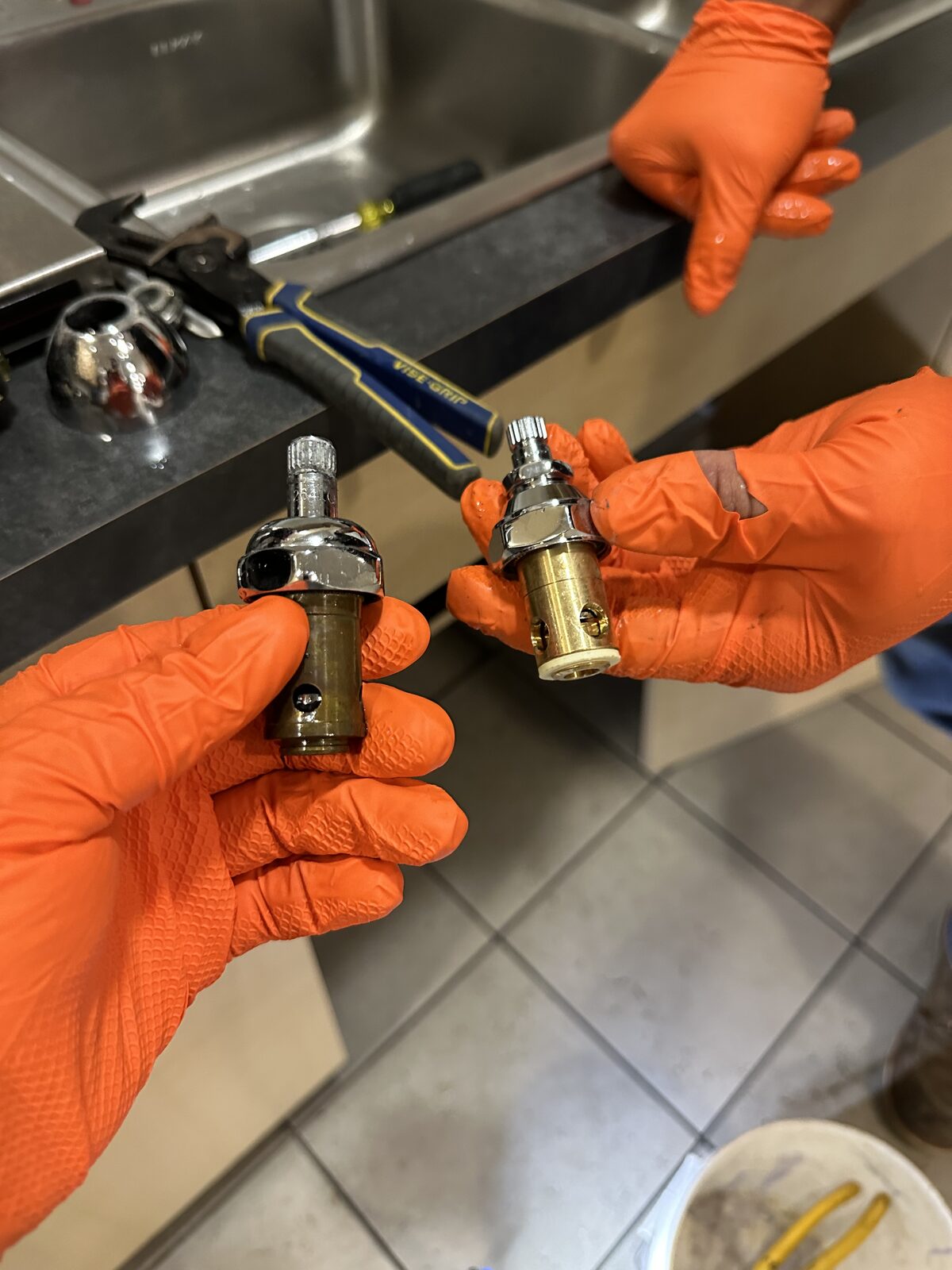 Old and new faucet cartridges held side by side for comparison