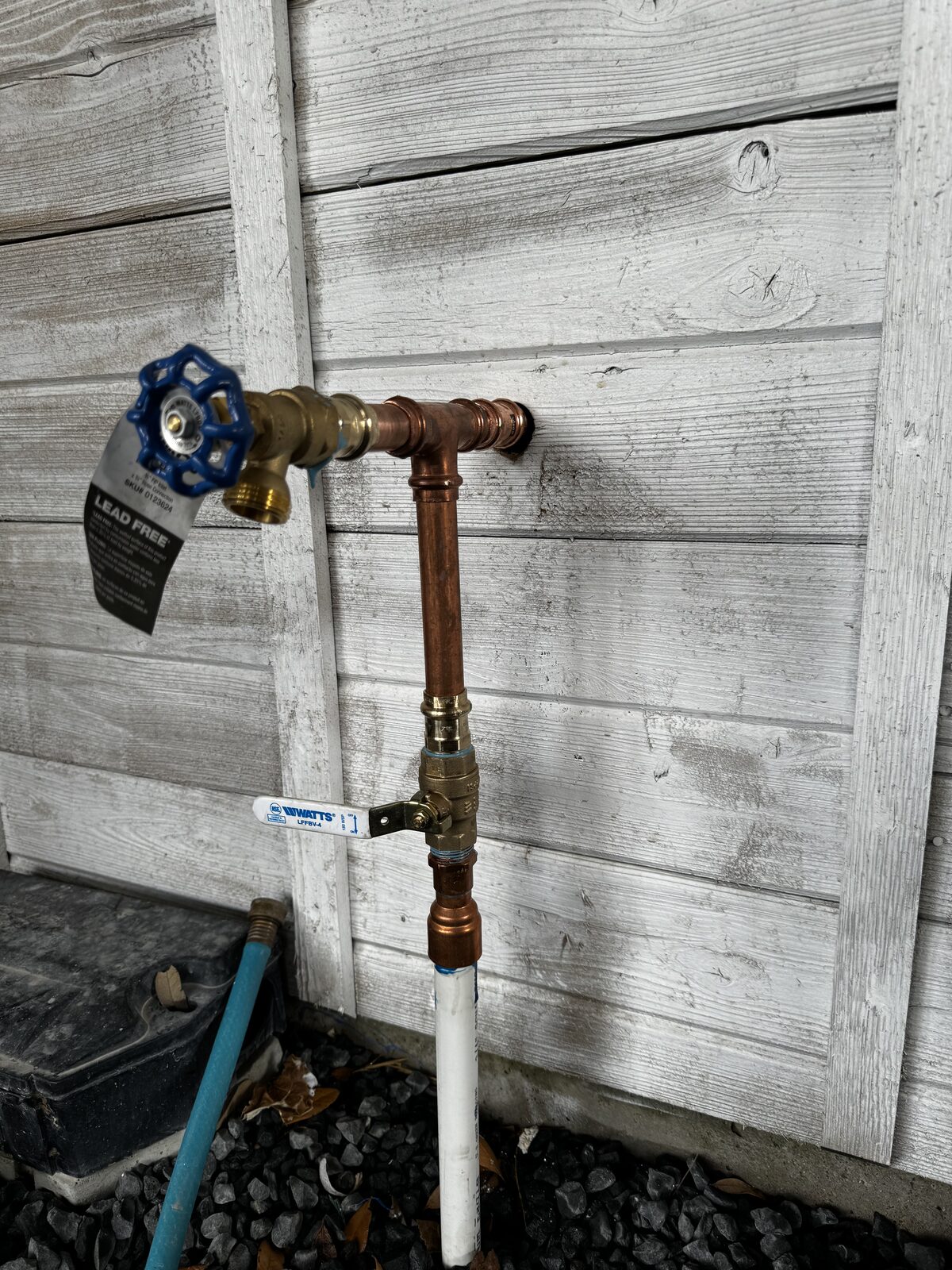New hose bib and Watts quarter-turn ball valve fitted to a wood-sided house in Beach City, TX