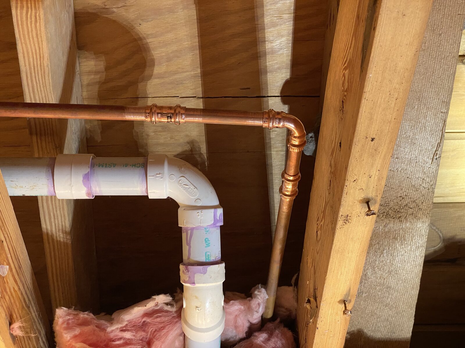 Copper pipe joined with Viega MegaPress press fittings in an attic surrounded by timber and insulation
