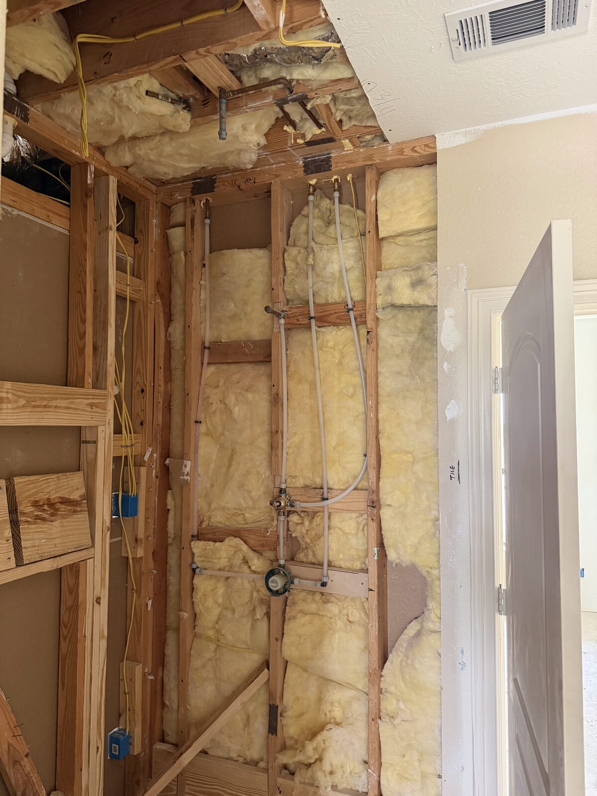 Uponor PEX risers run in an opened wall during a repipe