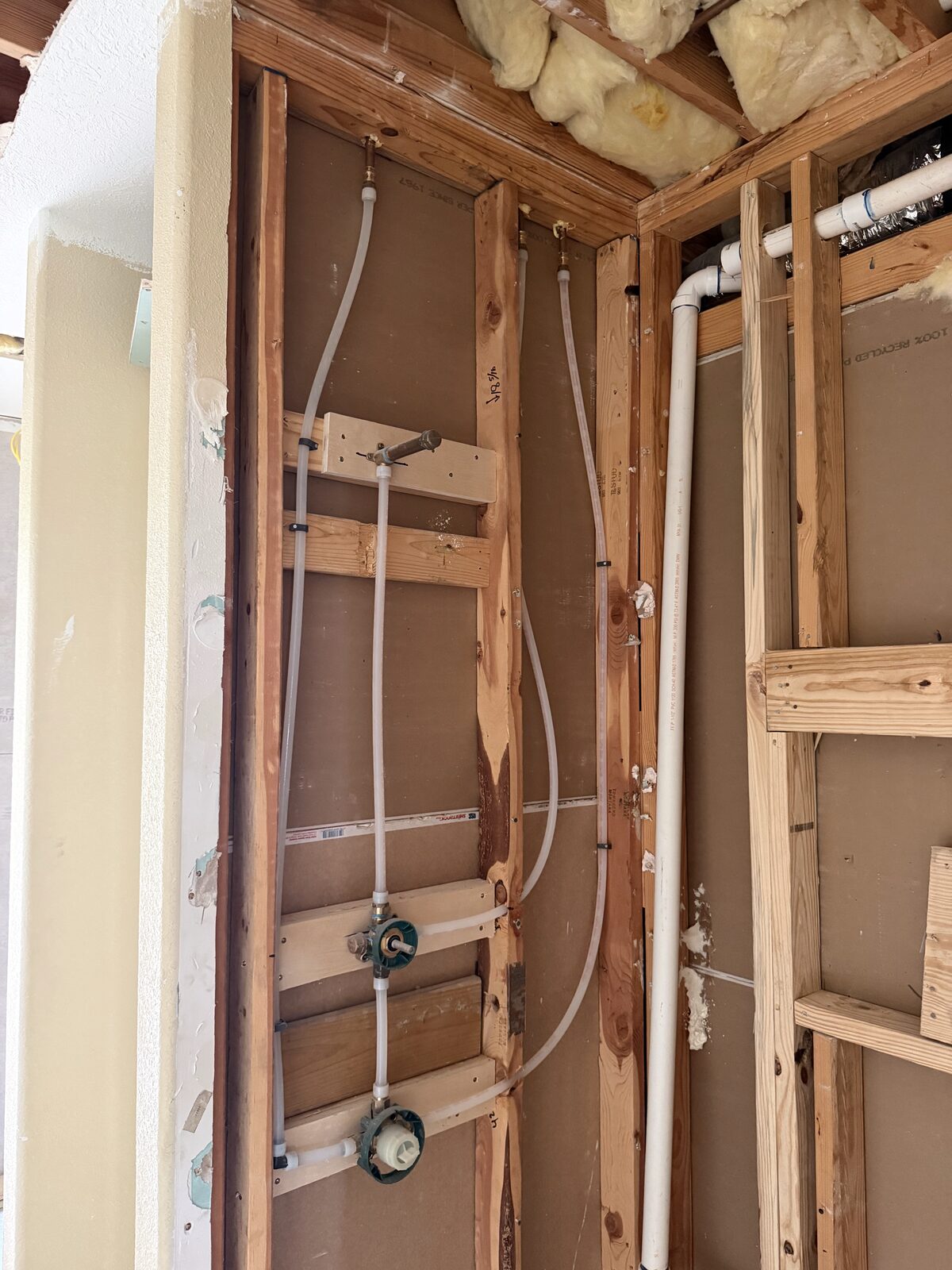 PEX water lines roughed in at a tub valve during a repipe