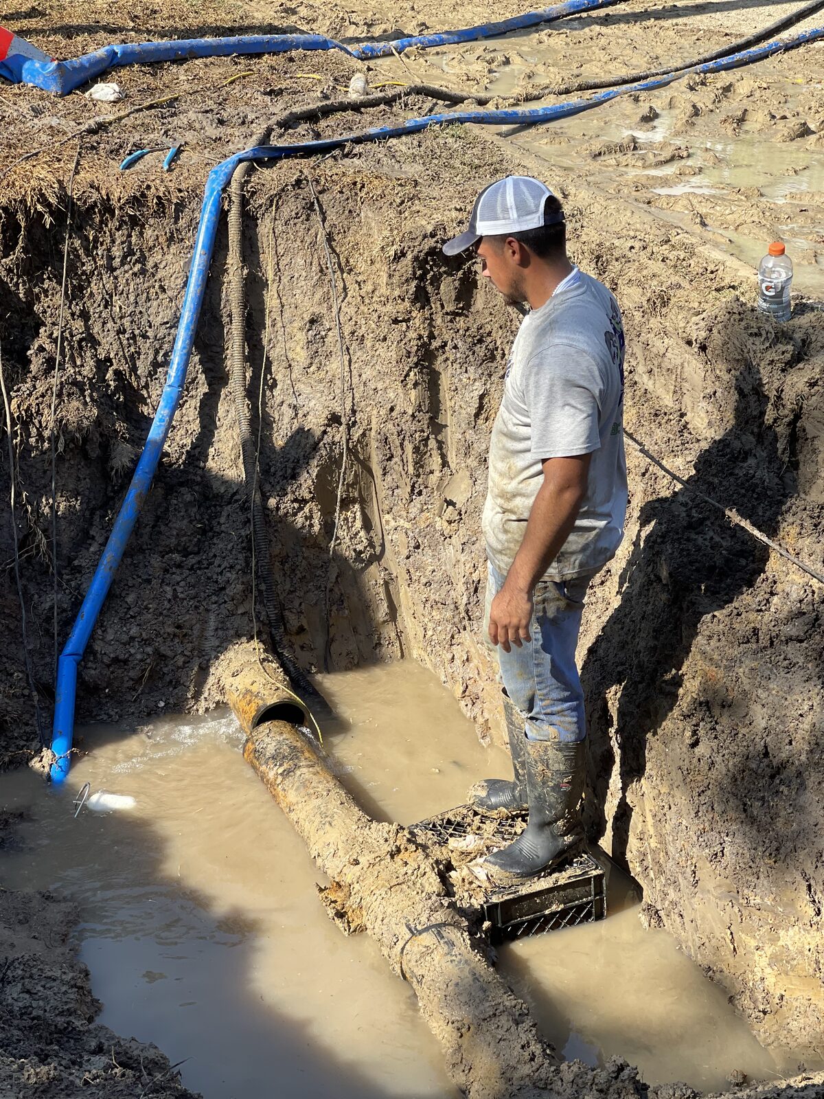Excavation to expose a buried sewer main in a yard