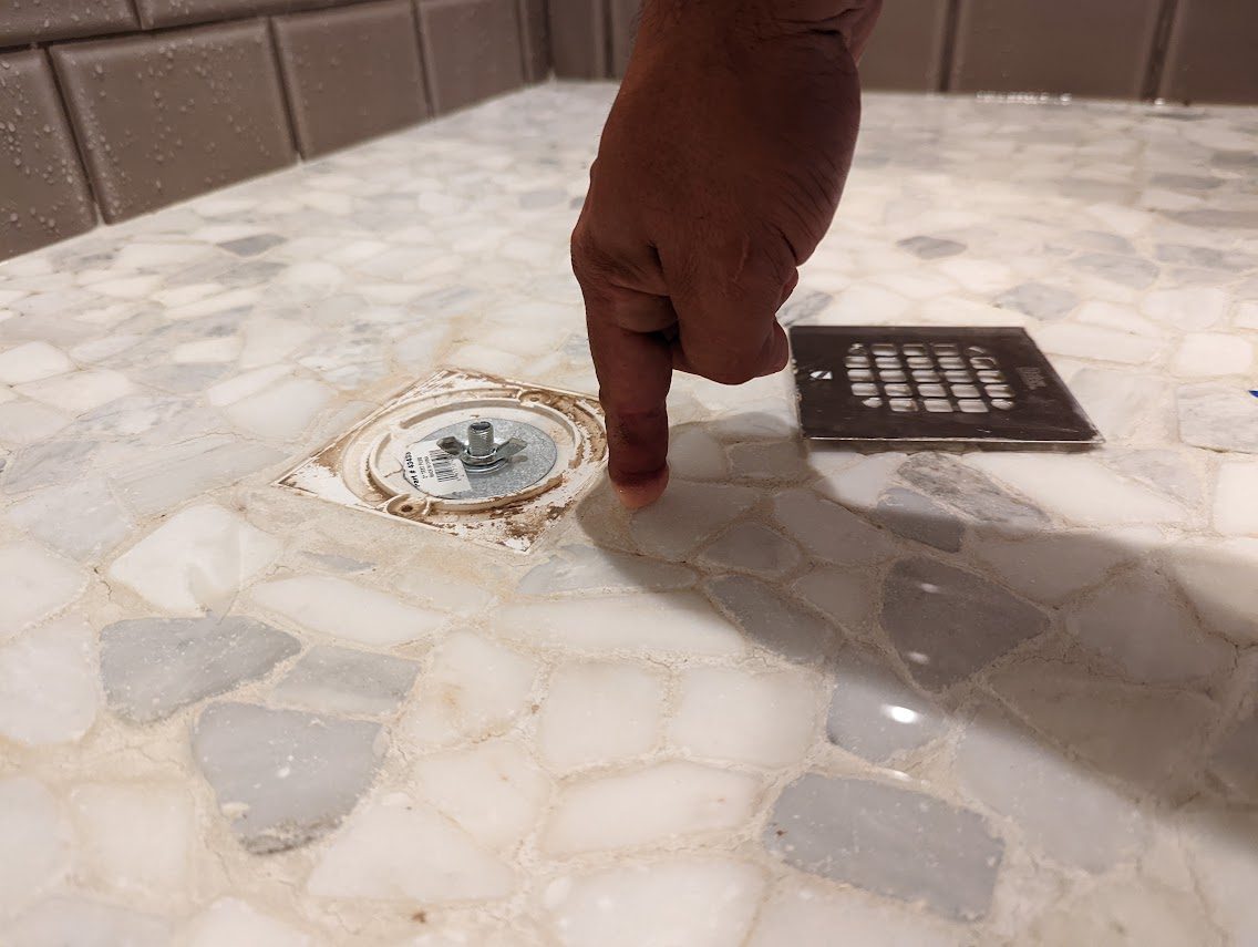 Shower pan drain being water-tested before the strainer is fitted