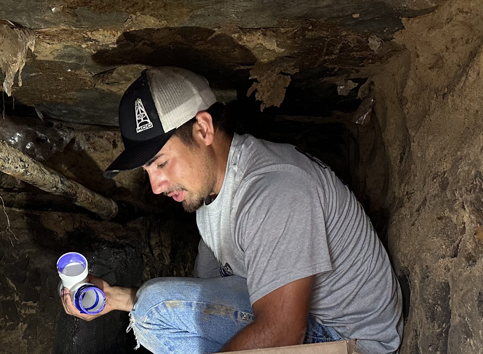 MVP Plumbing technician gluing fittings in a tunnel under a slab in Clear Lake, TX